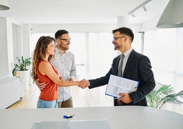 Agent and buyers shaking hands